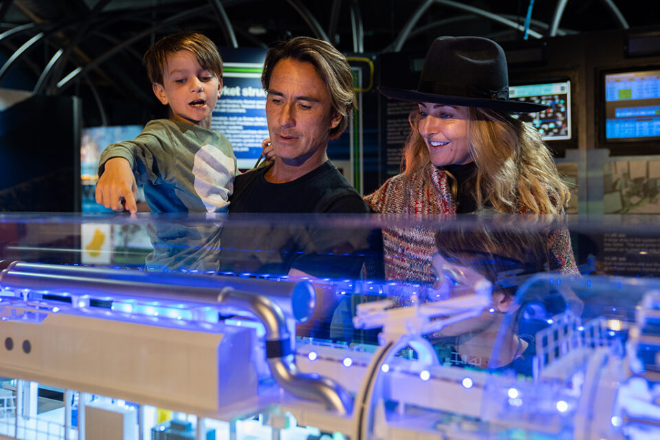 A family look at a display within museum