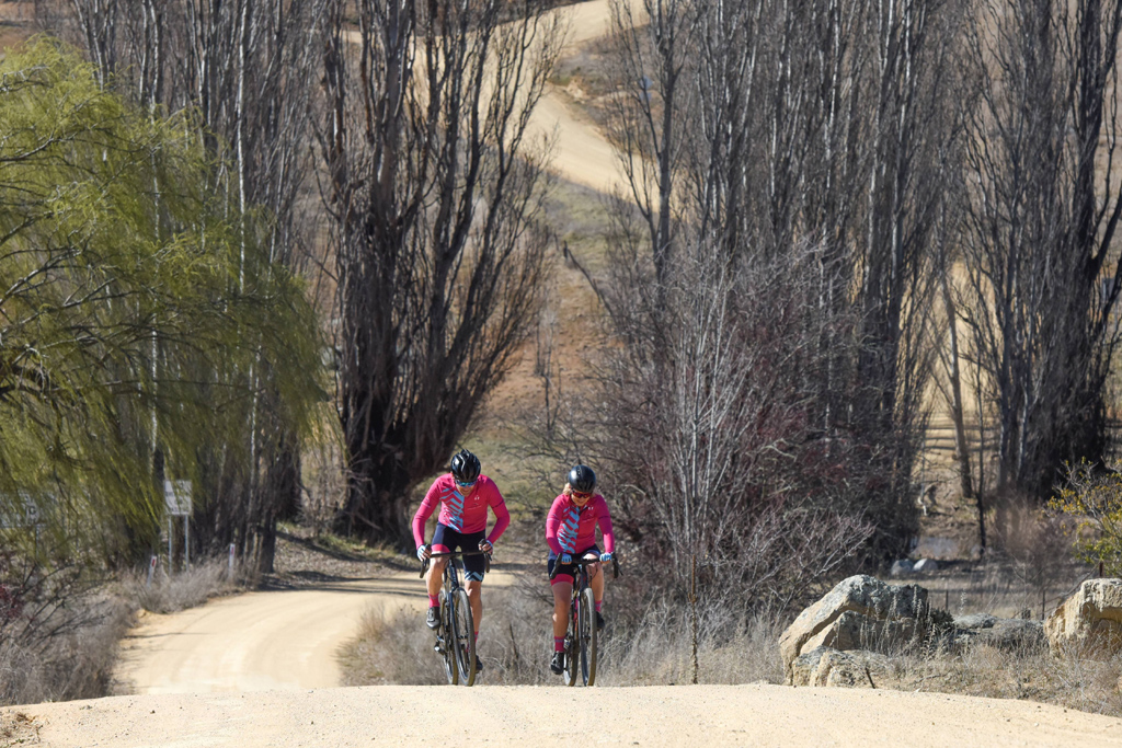 Two riders on gravel roads in the snowy mountains